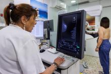 Dona realitzan-se una mamografia a la unitat de mama
